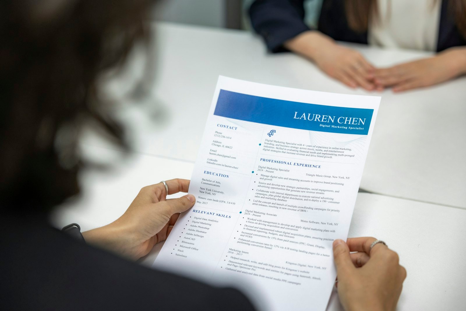 Reclutadora revisando un currículum impreso en una mesa de oficina